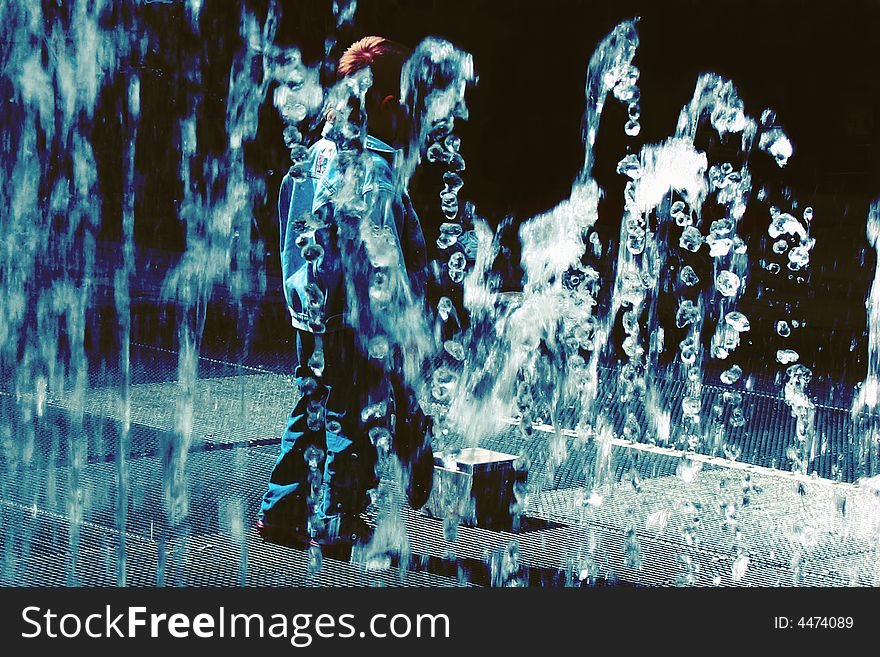 A child playing with moving sensor that trigger different water fountains. A child playing with moving sensor that trigger different water fountains