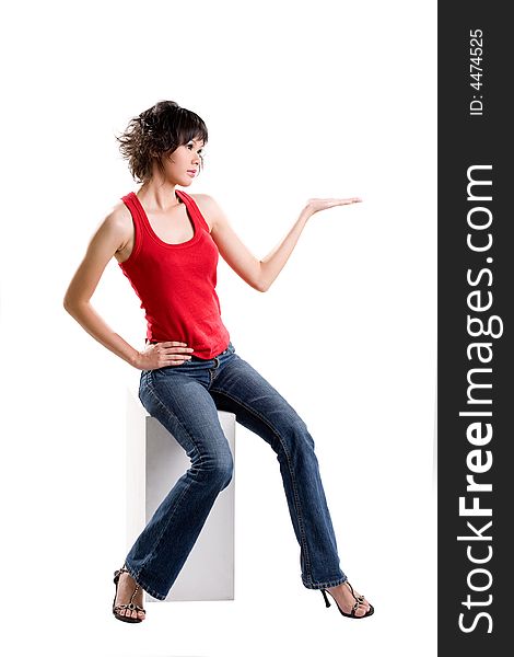 Young woman in red tank top and long jeans sitting and holding out her palm. Young woman in red tank top and long jeans sitting and holding out her palm