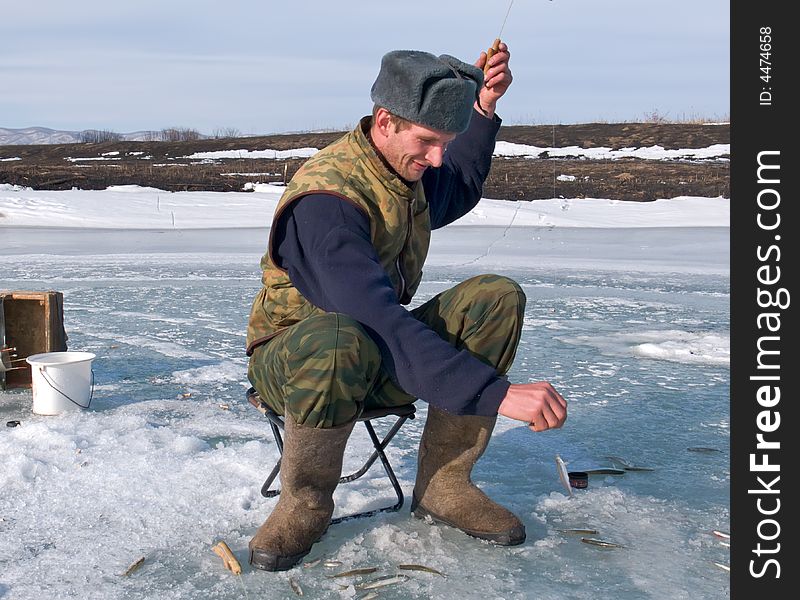 A winter fishing on river. People is fishing the smelt. Russian Far East, Primorye, Kievka river. A winter fishing on river. People is fishing the smelt. Russian Far East, Primorye, Kievka river.