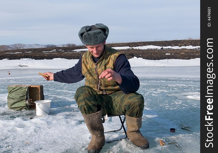 A winter fishing on river. People is fishing the smelt. Russian Far East, Primorye, Kievka river. A winter fishing on river. People is fishing the smelt. Russian Far East, Primorye, Kievka river.