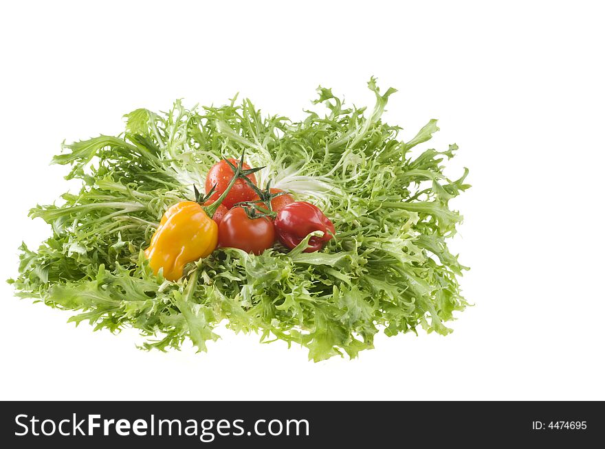 Hot color peppers and red ripe tomatoes on green leaf lettuce isolated over white background. Hot color peppers and red ripe tomatoes on green leaf lettuce isolated over white background