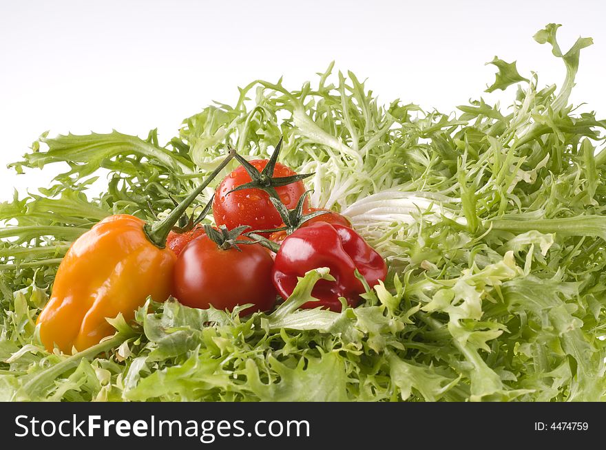 Hot color peppers and red ripe tomatoes on green lettuce leaves. Hot color peppers and red ripe tomatoes on green lettuce leaves