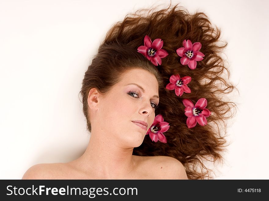 A woman with pink flowers in her hair. A woman with pink flowers in her hair