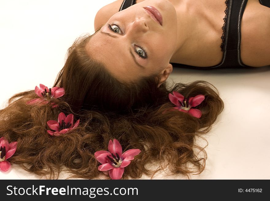 A woman lying on the ground with flowers in her hair. A woman lying on the ground with flowers in her hair