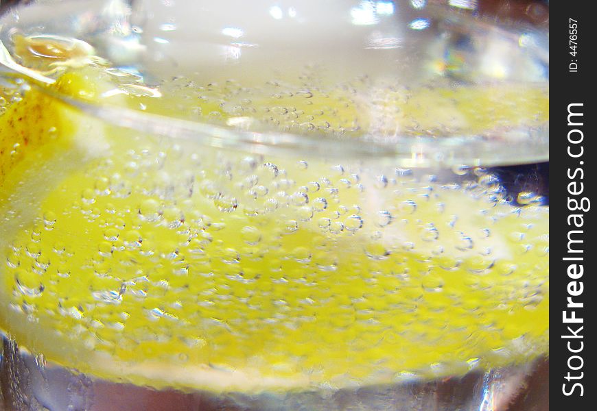 Lemon in a glass with bubbles