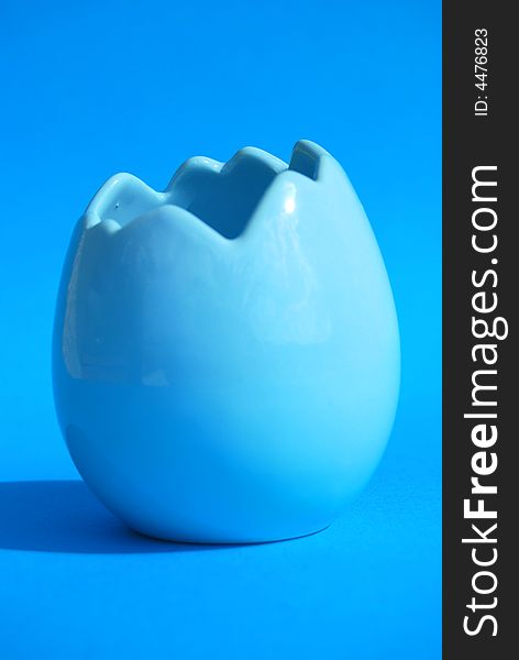 A blue egg shell on a blue background. A blue egg shell on a blue background