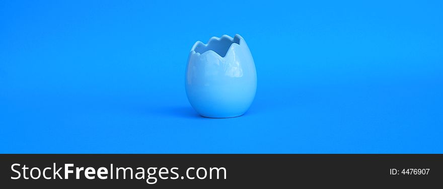 A blue egg shell on a blue background. A blue egg shell on a blue background