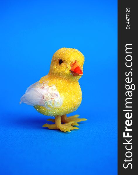 A yellow easter toy chick on blue background