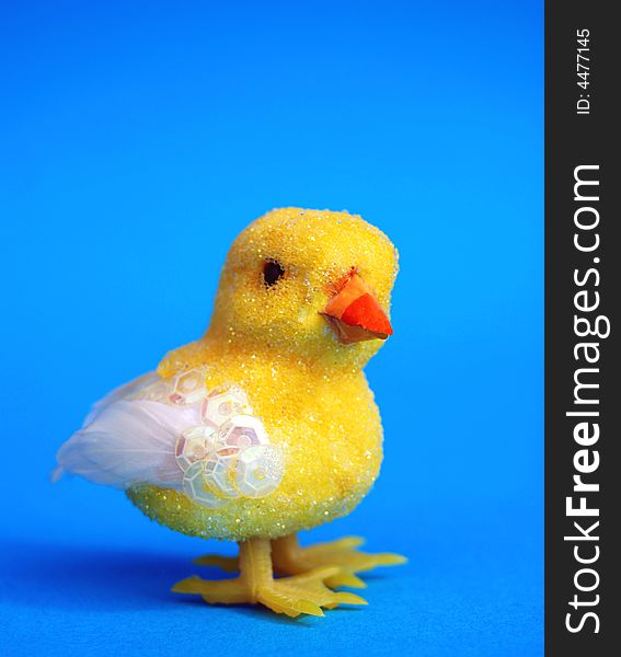 A yellow easter toy chick on blue background