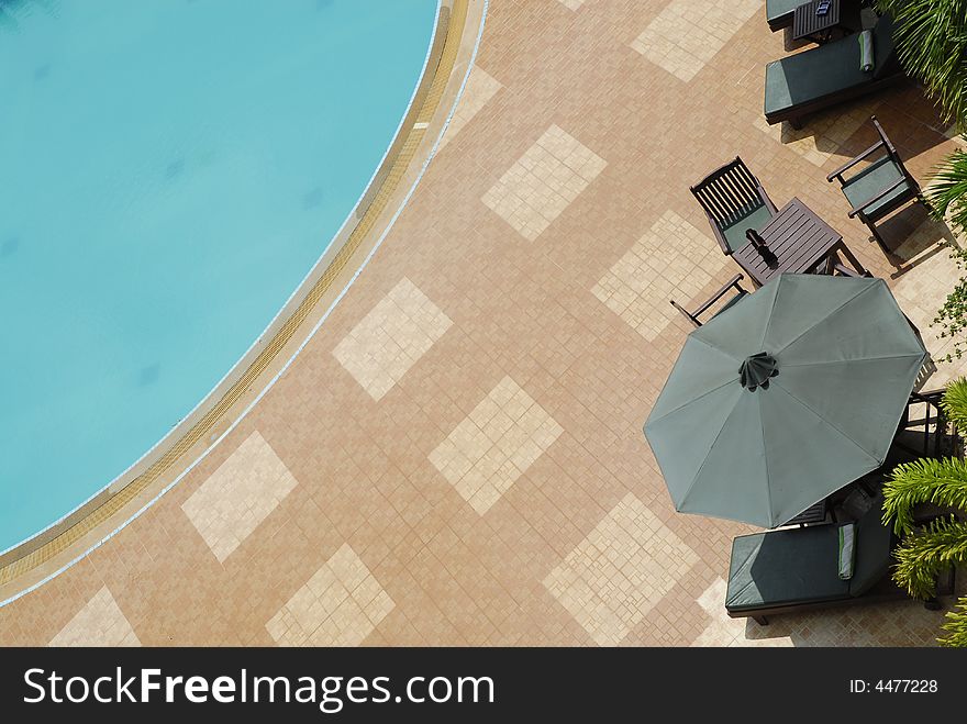 Looking down on a hotel swimming pool with seating. Looking down on a hotel swimming pool with seating