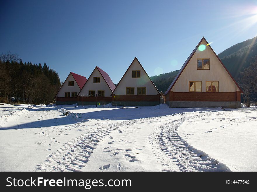 Four small houses stand on a solar glade. Four small houses stand on a solar glade