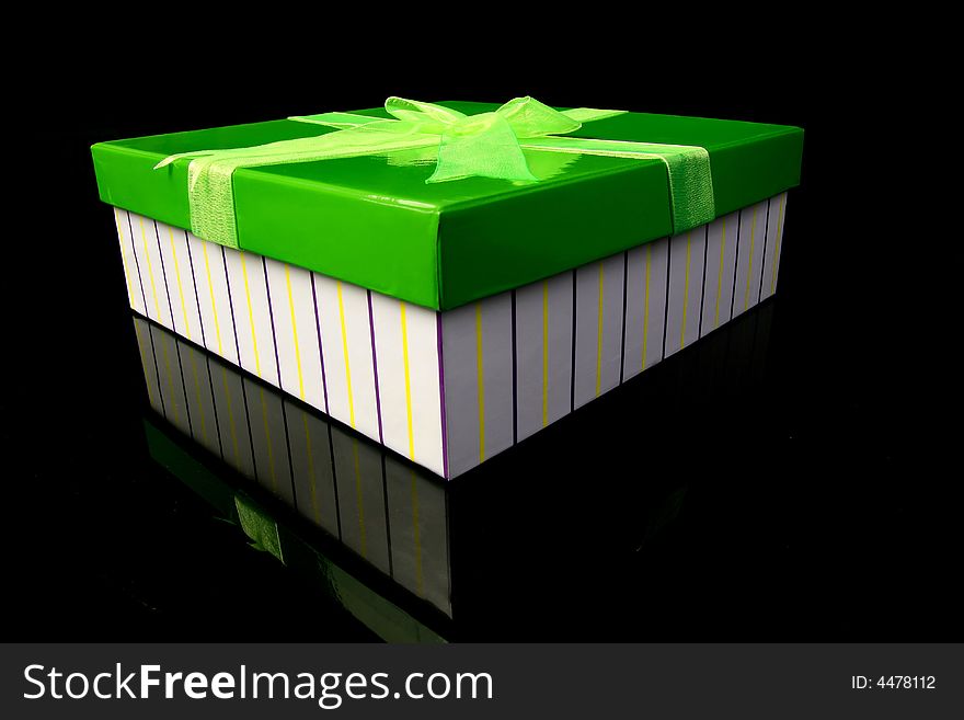 A green gift box standing on the glass