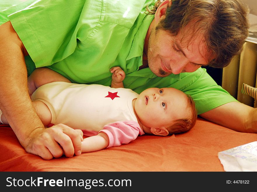 A small baby having father's finger. A small baby having father's finger