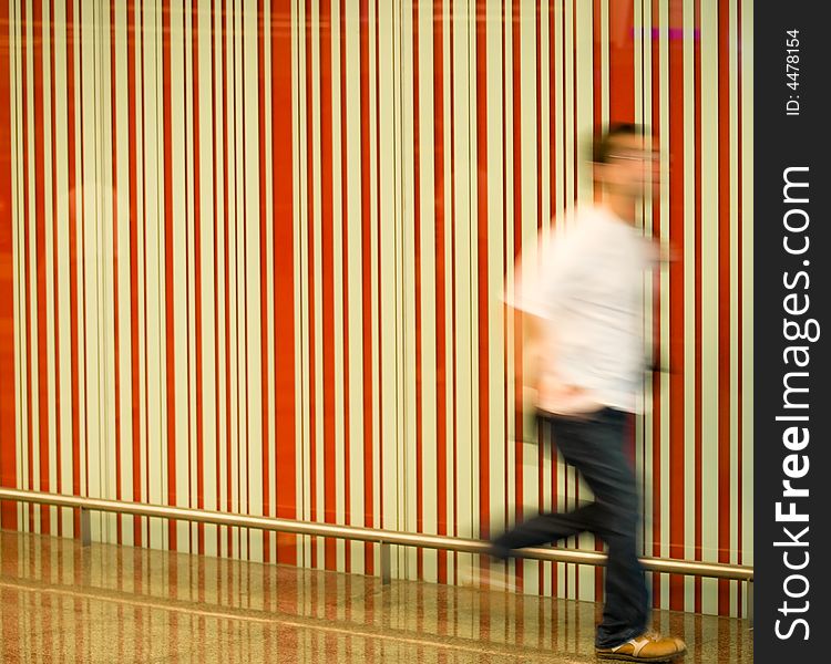 Blurred motion of a man running past a striped wall. Blurred motion of a man running past a striped wall