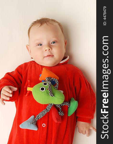 A baby in red with a toy