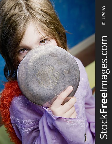 Little Girl Playing Dress-Up with an Antique Handheld Mirror. Little Girl Playing Dress-Up with an Antique Handheld Mirror