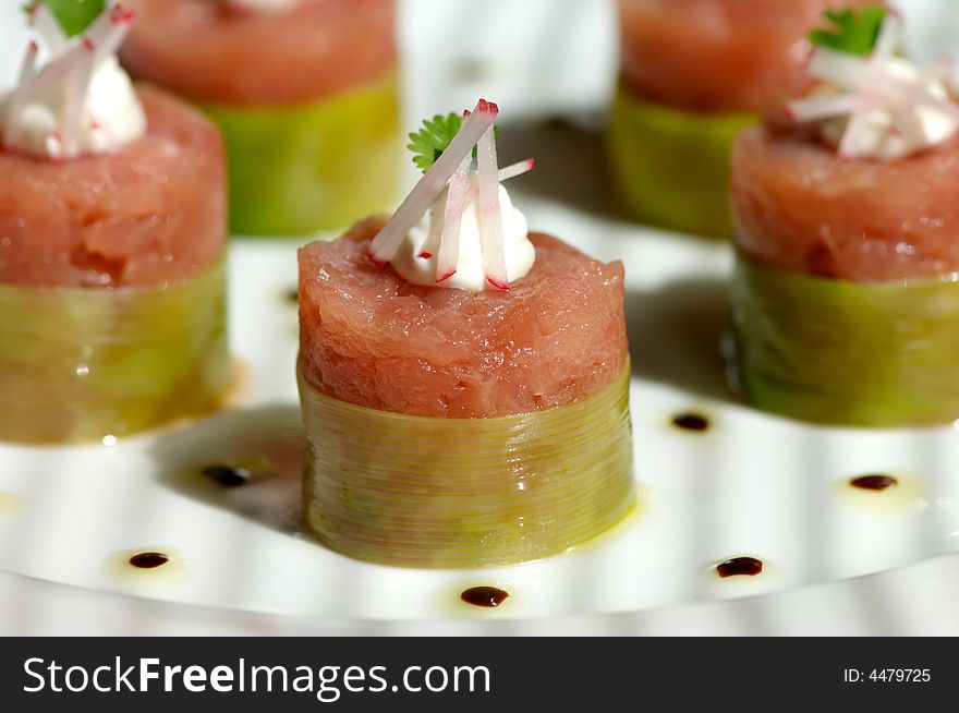 Image of raw tuna wrapped in bamboo and topped with garnish. Image of raw tuna wrapped in bamboo and topped with garnish