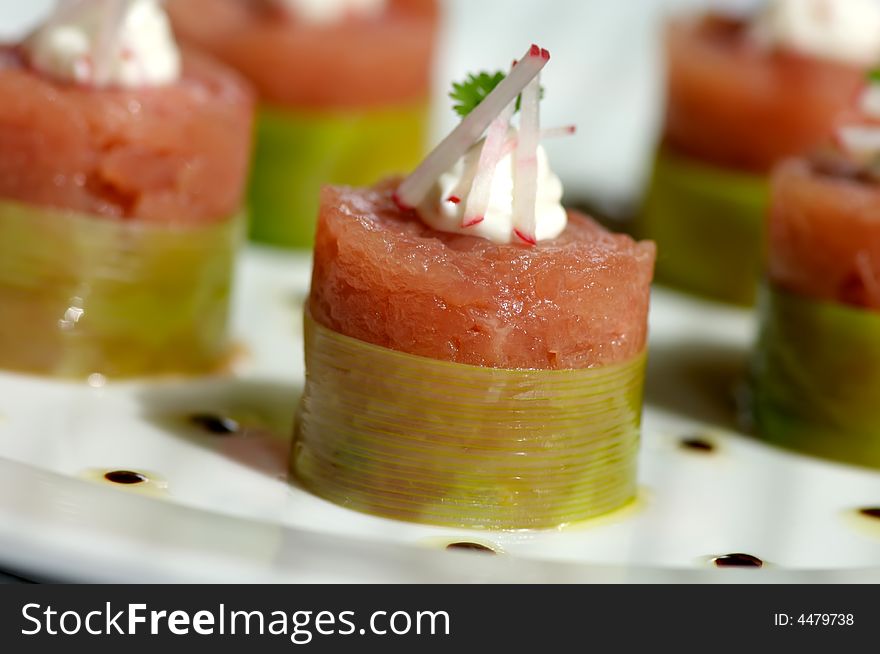Image of raw tuna wrapped in bamboo and topped with garnish. Image of raw tuna wrapped in bamboo and topped with garnish