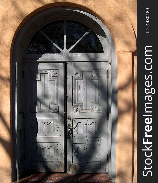 Church door shadowed by image of a tree. Church door shadowed by image of a tree.