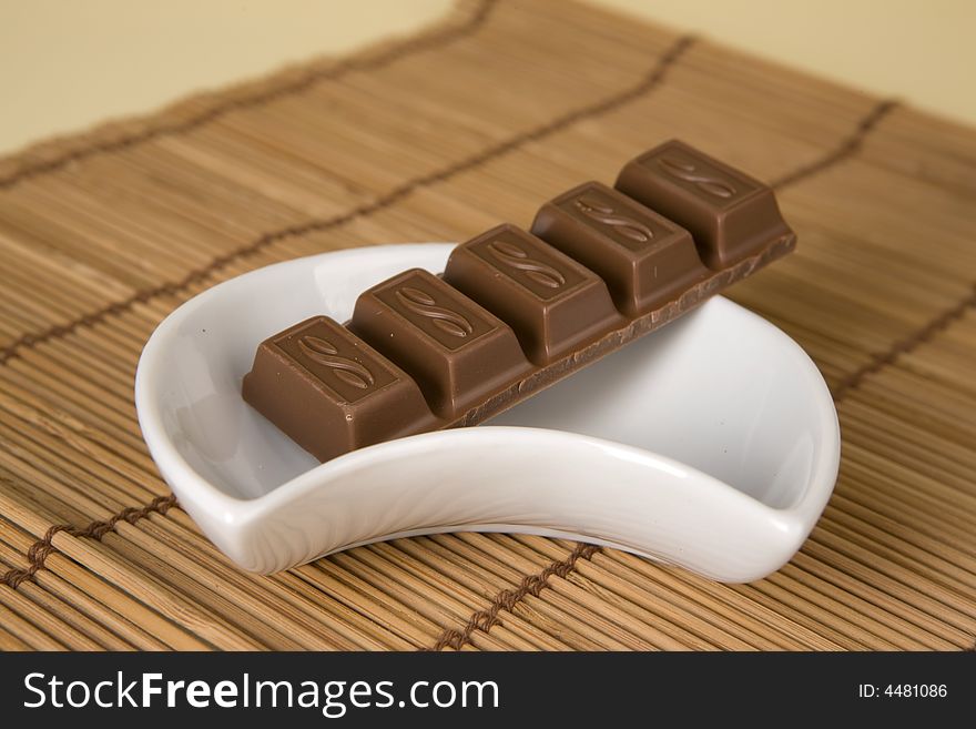 Chocolate in white cup on brown background