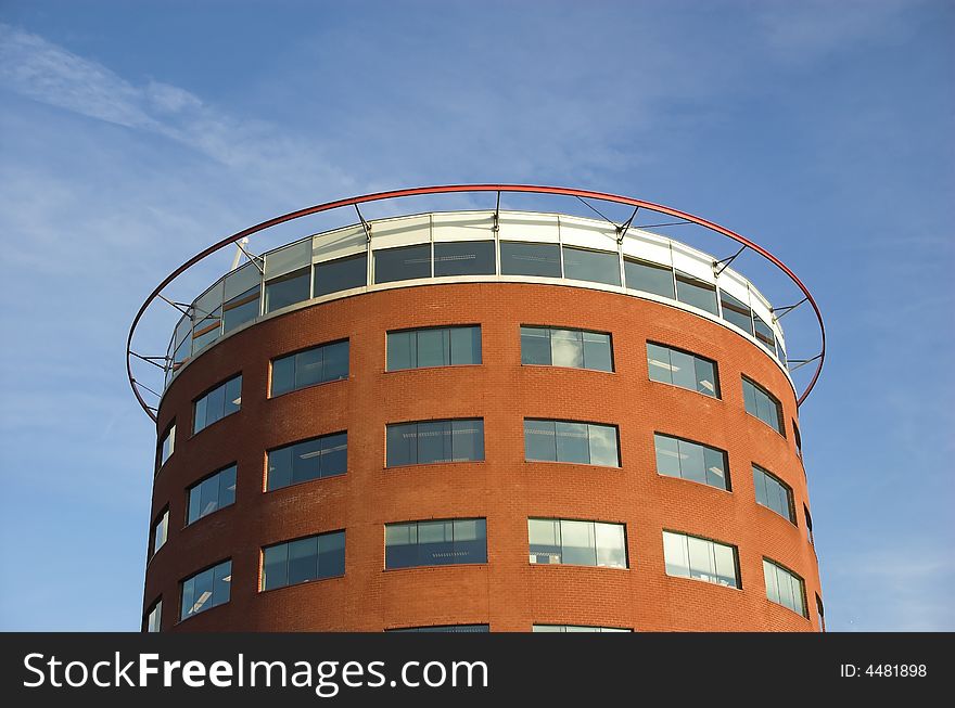Modern round-shaped office building made of red brick and glass in Hoogvliet, Holland