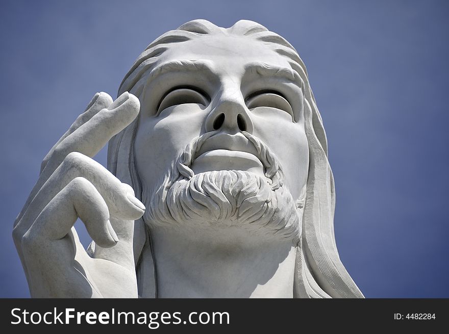 Jesus Christ statue against blue sky