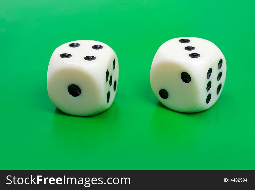 Two gambling dices on green background