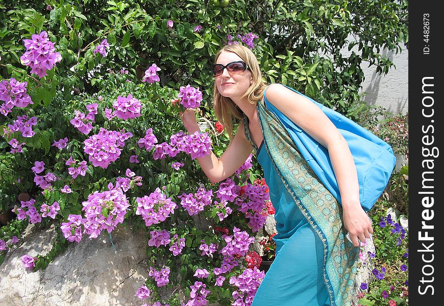 The beautiful girl is smelling flowers of bougainvillea. The beautiful girl is smelling flowers of bougainvillea