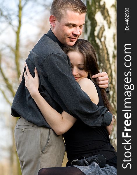 Man and girlfriend on a bench in a park caring. Man and girlfriend on a bench in a park caring