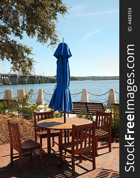 A restaurant table outside by the sea side. A restaurant table outside by the sea side.