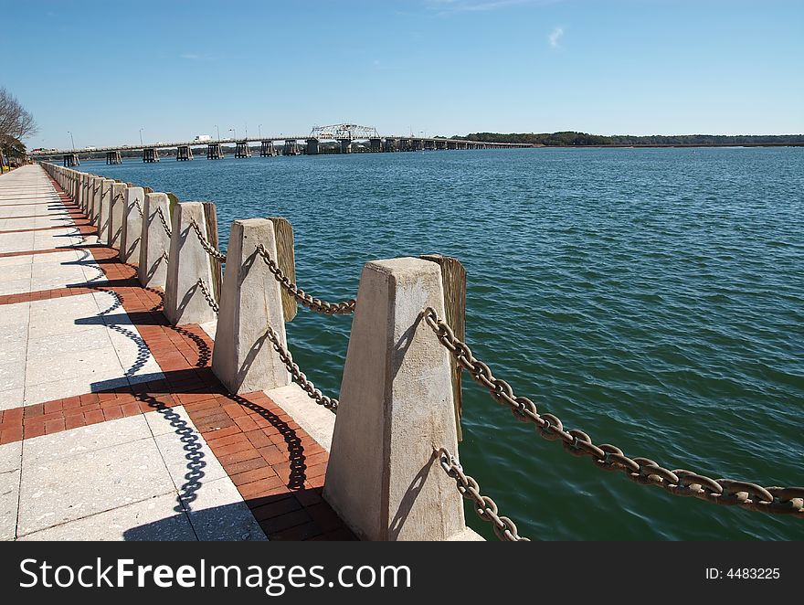 A chained fence wall on the edge of a boardwalk overlooking the ocean. A chained fence wall on the edge of a boardwalk overlooking the ocean.