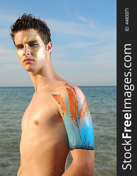 Young model on the beach wearing artistic bodypaint drawing. Young model on the beach wearing artistic bodypaint drawing