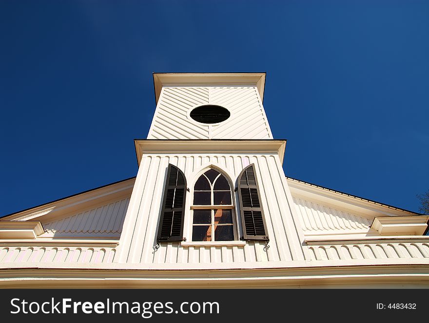 An old church steeple in front of a blue sky. An old church steeple in front of a blue sky.