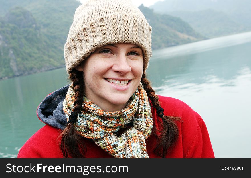 Portrait of a happy natural looking woman in winter clothing with mountains in the background. Portrait of a happy natural looking woman in winter clothing with mountains in the background.