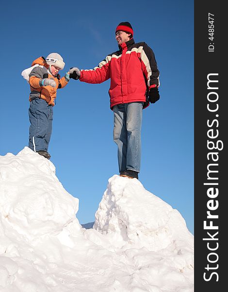 Father with child stand on snow hill