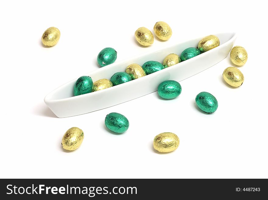 Green and gold chocolate easter eggs in a white bowl. Green and gold chocolate easter eggs in a white bowl