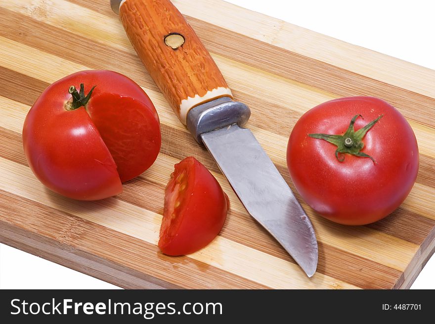 Juicy tomato on wooden plate in the studio