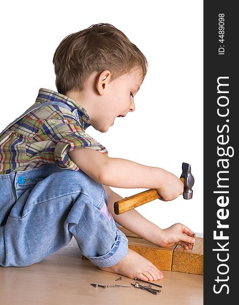 Playful kid hammers a hammer in nails