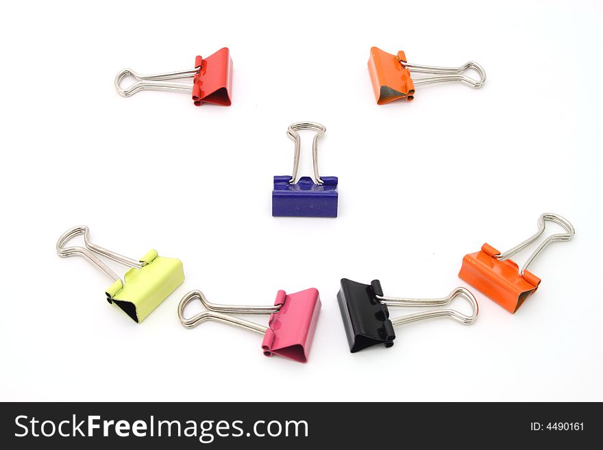 Face smiling formed by colorful binder clips on a white surface. Face smiling formed by colorful binder clips on a white surface