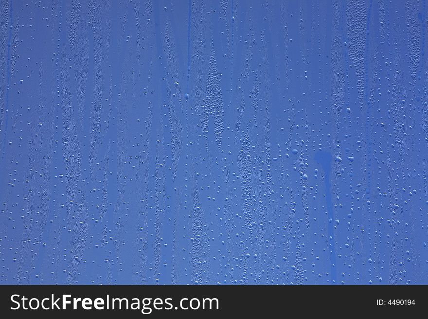 Drops on window with blue background