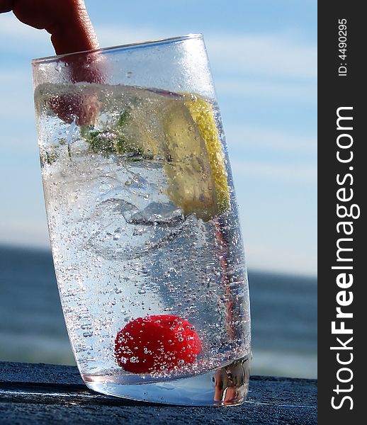 A refreshing cocktail drink with a cherry and slice of lemon