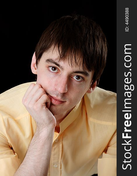 Young man in yellow shirt on black background