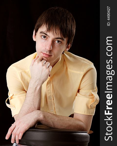 Young man in yellow shirt on black background
