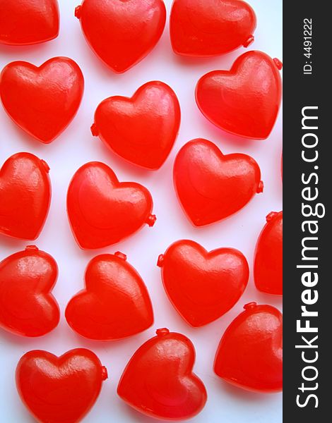 Red plastic love hearts on a white background