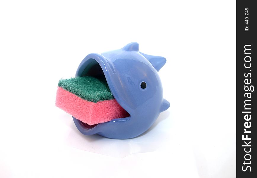 Red and green cleaning sponge in a blue fish soap dish. Red and green cleaning sponge in a blue fish soap dish