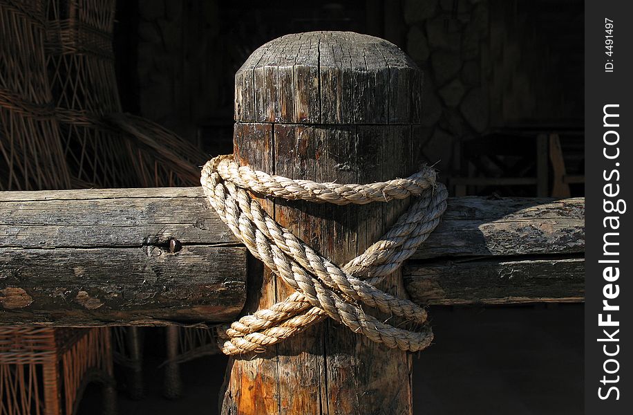 Wooden fence and rope on black background