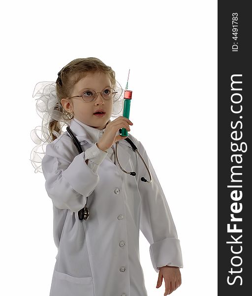 The girl plays with a syringe and a stethoscope and dreams to become the doctor. Isolated on white background. The girl plays with a syringe and a stethoscope and dreams to become the doctor. Isolated on white background.