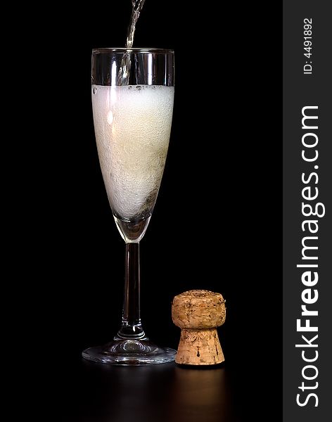 Champagne glass and a cork in black background. Champagne glass and a cork in black background.