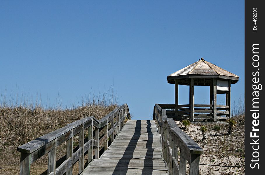 Wood walkway over dunes to beach and beach front gazebo. Wood walkway over dunes to beach and beach front gazebo.