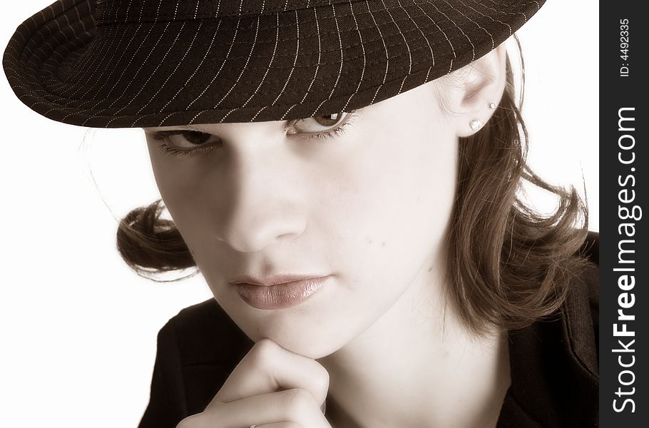 Wary teen wearing a pin-striped fedora hat.  Sepia toned, isolated on white.